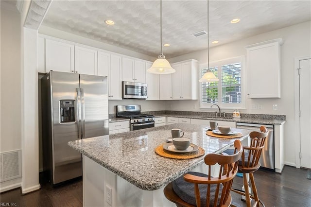 209 Cobblestone Reach Reach, Suffolk, VA 23435 - kitchen featuring appliances with stainless steel finishes, a sink, visible vents, and a kitchen breakfast bar