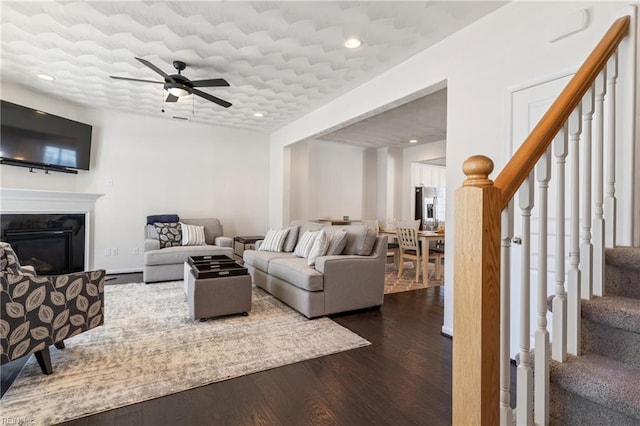 209 Cobblestone Reach Reach, Suffolk, VA 23435 - living room with ceiling fan, a glass covered fireplace, recessed lighting, stairs, and dark wood-style floors