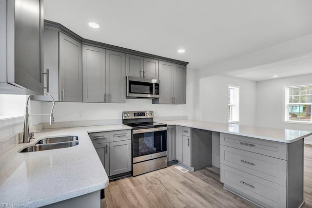 9289 Gates Rd, Suffolk, VA 23437 - kitchen featuring a peninsula, appliances with stainless steel finishes, a sink, and gray cabinetry