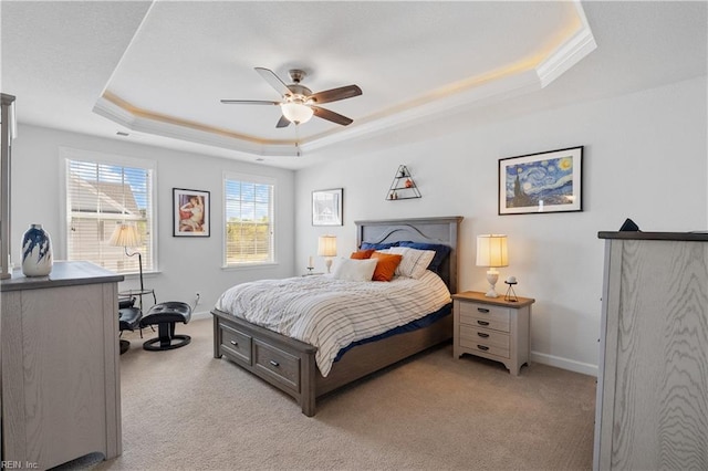 bedroom featuring a ceiling fan, crown molding, a raised ceiling, light colored carpet, and baseboards
