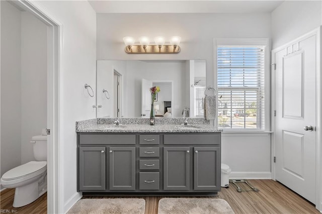 full bath with baseboards, toilet, wood finished floors, and a wealth of natural light