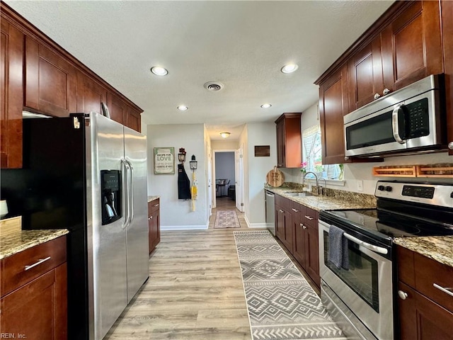 kitchen featuring recessed lighting, stainless steel appliances, light wood-style flooring, and a sink