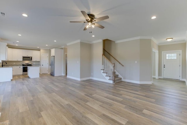 unfurnished living room with baseboards, light wood-style flooring, crown molding, stairs, and ceiling fan