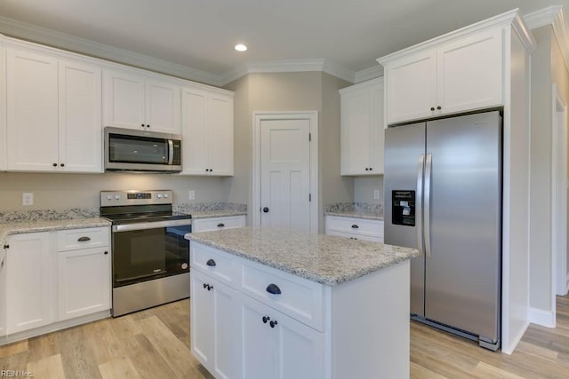 kitchen featuring ornamental molding, recessed lighting, white cabinets, appliances with stainless steel finishes, and light wood finished floors