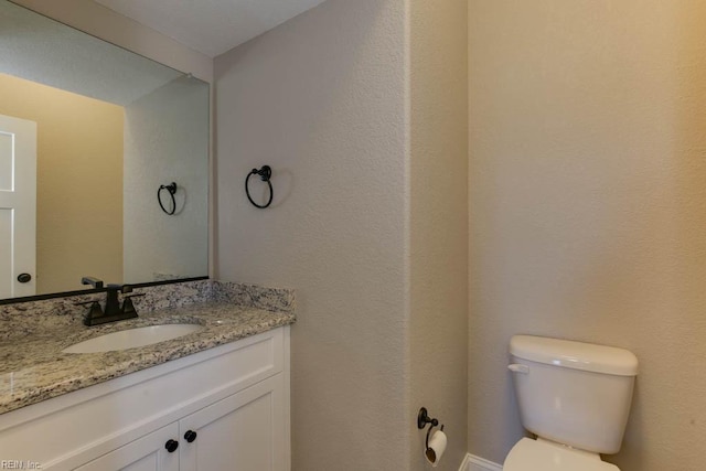 half bathroom featuring toilet and vanity