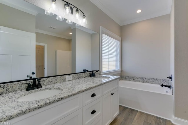 bathroom featuring a sink, ornamental molding, visible vents, and wood finished floors