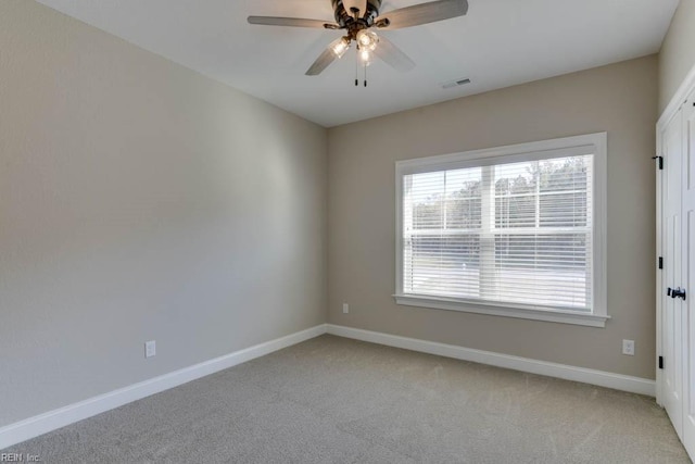 unfurnished room with light carpet, visible vents, baseboards, and a ceiling fan