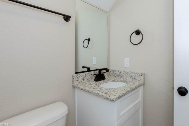 half bathroom with toilet and vanity