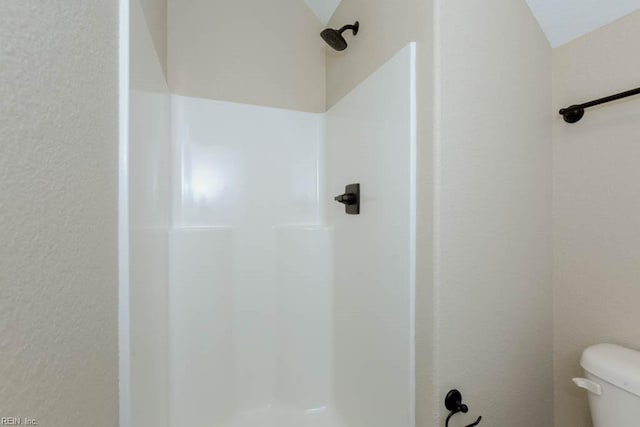 bathroom featuring a shower stall and toilet