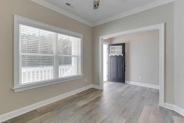 unfurnished room featuring visible vents, baseboards, ornamental molding, ceiling fan, and wood finished floors
