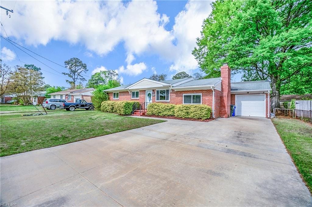 ranch-style home featuring a chimney, concrete driveway, fence, brick siding, and an attached garage
