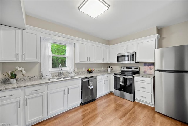 105 Ireland St, Hampton, VA 23663 - kitchen with light stone counters, white cabinets, stainless steel appliances, light wood finished floors, and a sink