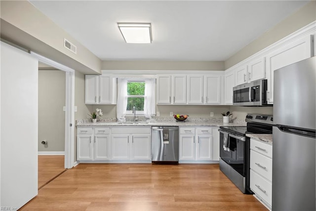 105 Ireland St, Hampton, VA 23663 - kitchen with white cabinets, light stone countertops, visible vents, appliances with stainless steel finishes, and a sink