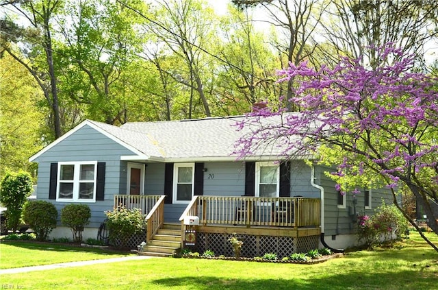 ranch-style home featuring a porch, roof with shingles, and a front lawn