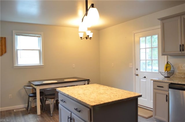 kitchen with an inviting chandelier, dishwasher, light wood-type flooring, gray cabinets, and a kitchen island