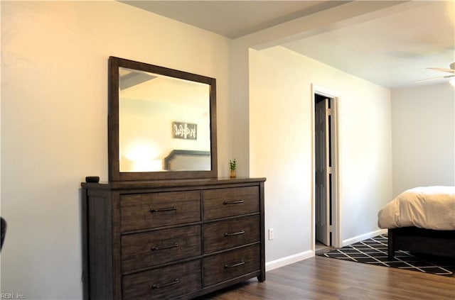 bedroom with dark wood-type flooring and baseboards