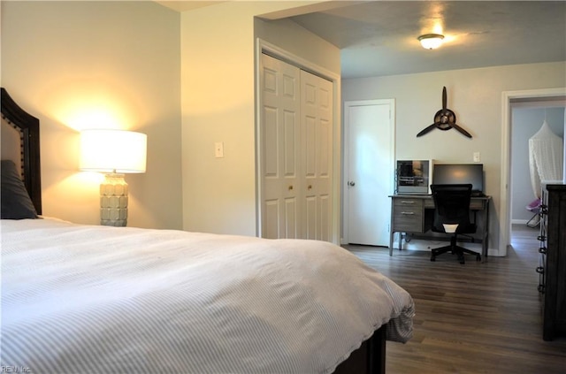 bedroom with dark wood-type flooring, a closet, and baseboards