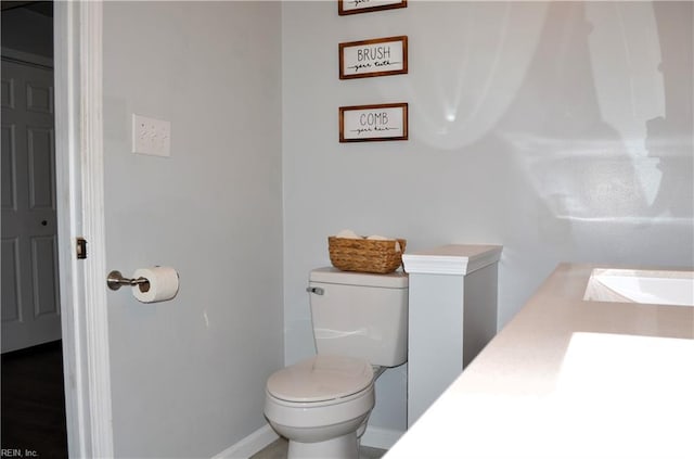 bathroom featuring toilet, a sink, and baseboards