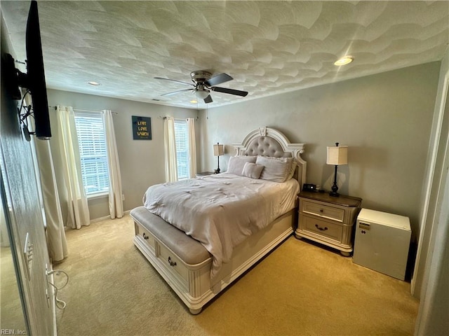bedroom with a ceiling fan and light colored carpet