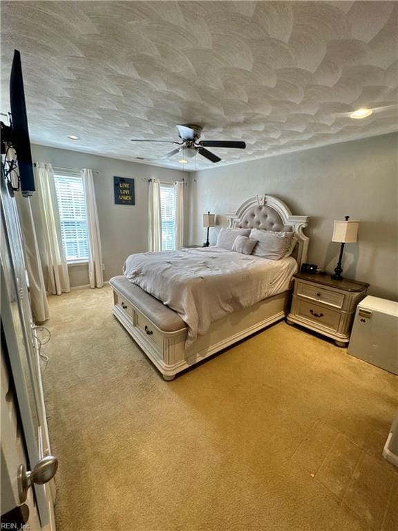 bedroom with ceiling fan and light carpet