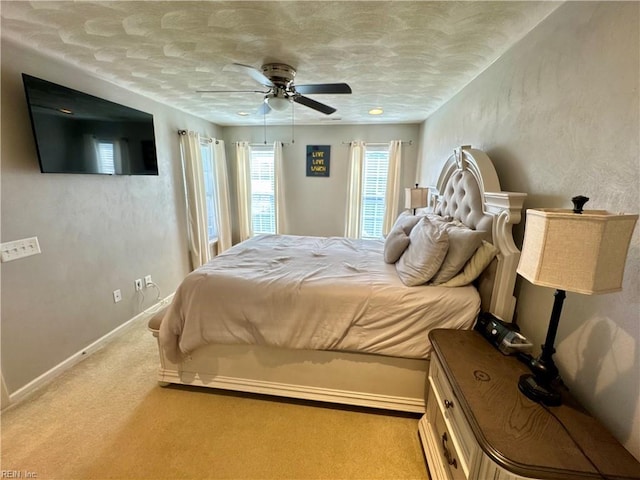 carpeted bedroom featuring baseboards and ceiling fan