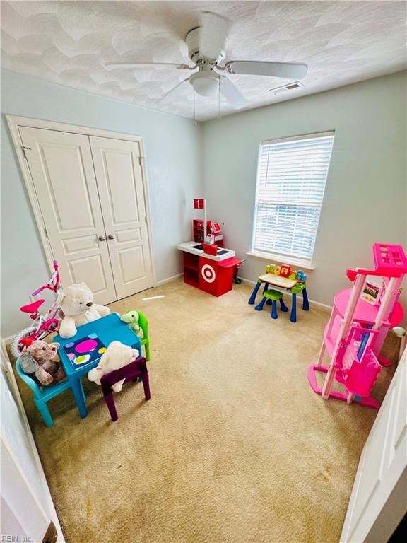 playroom with baseboards, visible vents, carpet, and ceiling fan