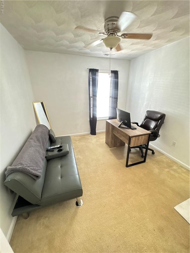 office space with ceiling fan, light carpet, and baseboards