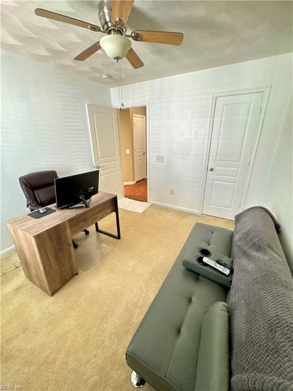 office area with ceiling fan, baseboards, and light colored carpet