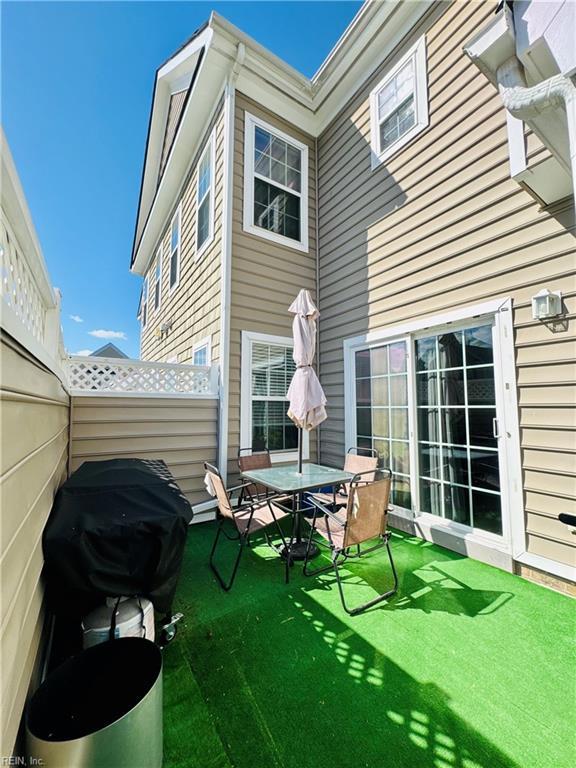 rear view of property featuring a lawn and a patio area