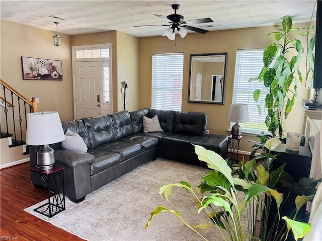 living room with stairway, baseboards, a ceiling fan, and wood finished floors