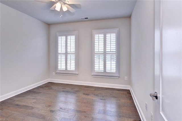 empty room featuring ceiling fan, baseboards, dark wood-type flooring, and visible vents