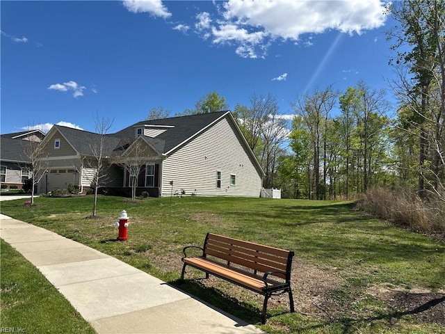 view of home's community featuring a yard and an attached garage