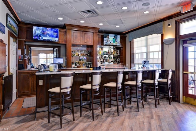 bar featuring recessed lighting, visible vents, an ornate ceiling, a wealth of natural light, and a community bar