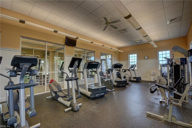 workout area with baseboards, a paneled ceiling, visible vents, and ceiling fan