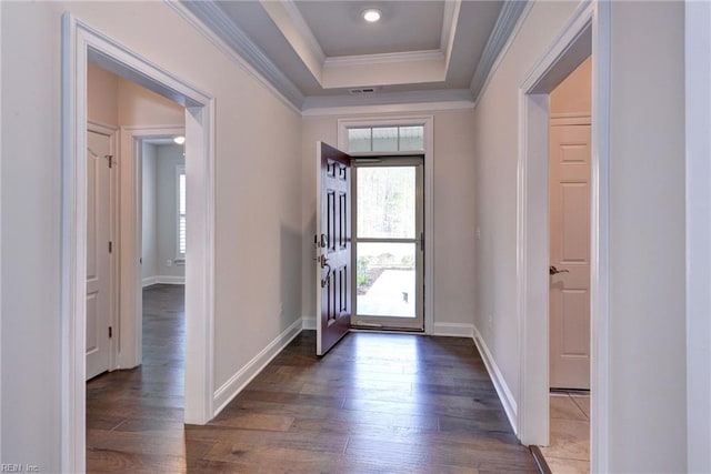 foyer entrance with baseboards, a tray ceiling, ornamental molding, and dark wood finished floors