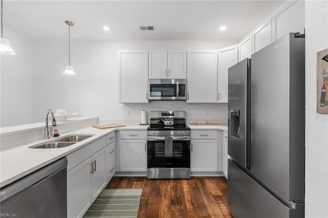 kitchen with light countertops, dark wood finished floors, appliances with stainless steel finishes, and a sink