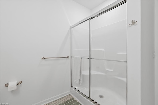 full bathroom with baseboards and a stall shower