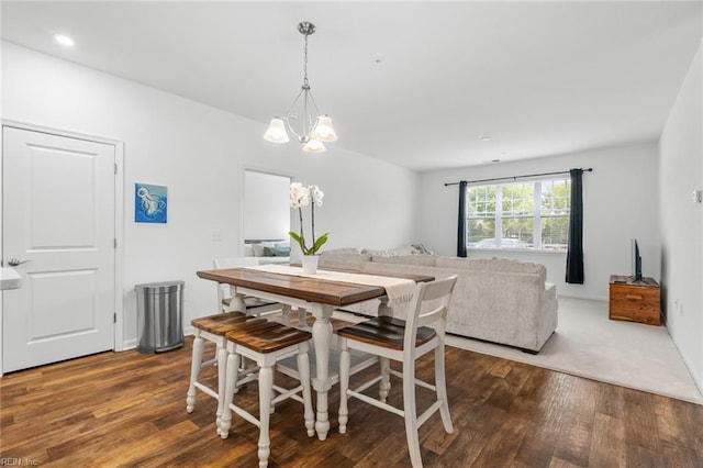 dining space with wood finished floors and a notable chandelier
