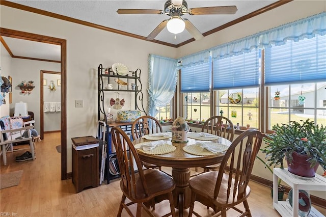dining space with light wood-style floors, ceiling fan, baseboards, and ornamental molding