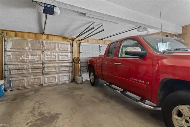 garage with a garage door opener and wooden walls