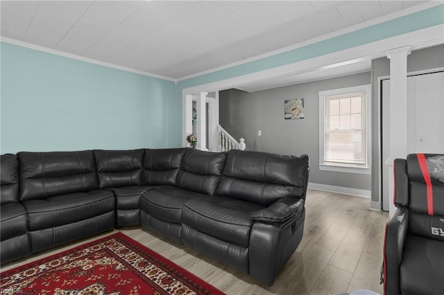 living area featuring wood finished floors, decorative columns, baseboards, and ornamental molding