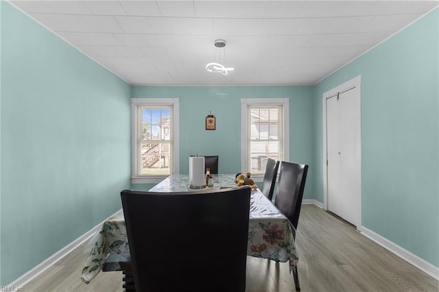 dining space featuring baseboards and wood finished floors