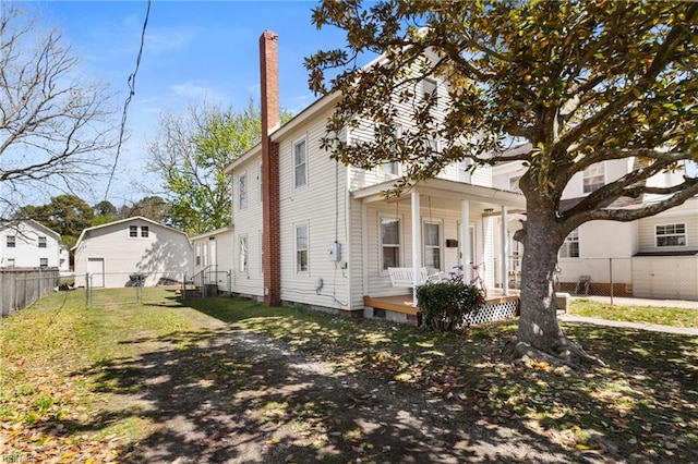 view of front of home with central AC unit, a porch, a chimney, a fenced backyard, and a front lawn