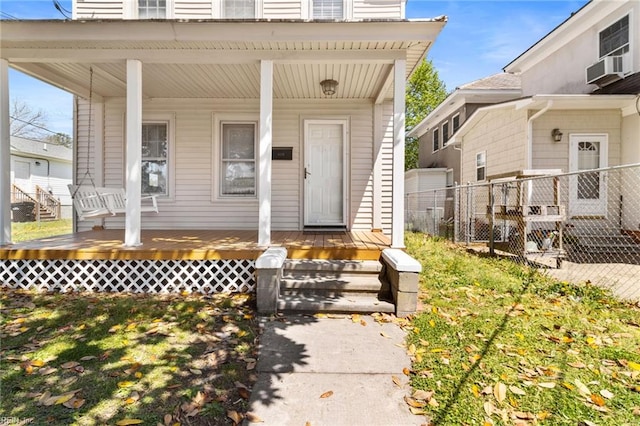 property entrance with a porch and fence