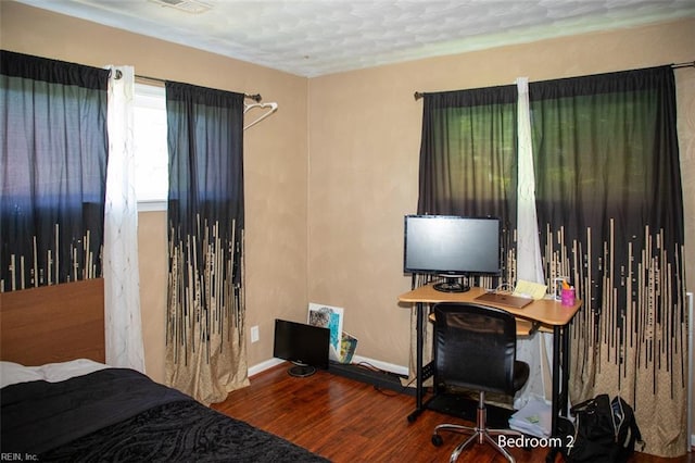 bedroom featuring wood finished floors and baseboards