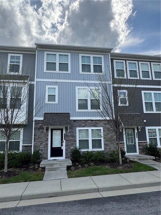 townhome / multi-family property featuring stone siding and board and batten siding