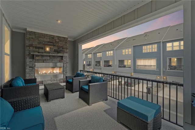 view of patio with an outdoor living space with a fireplace and a balcony