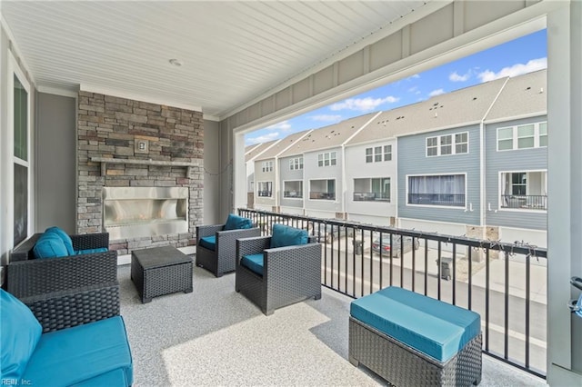 view of patio / terrace featuring a residential view, a balcony, and an outdoor living space with a fireplace