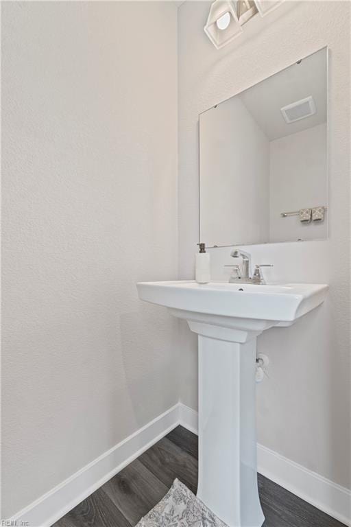 bathroom with baseboards and wood finished floors