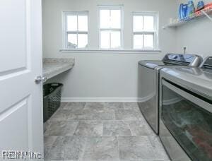 laundry area featuring a wealth of natural light, separate washer and dryer, laundry area, and baseboards